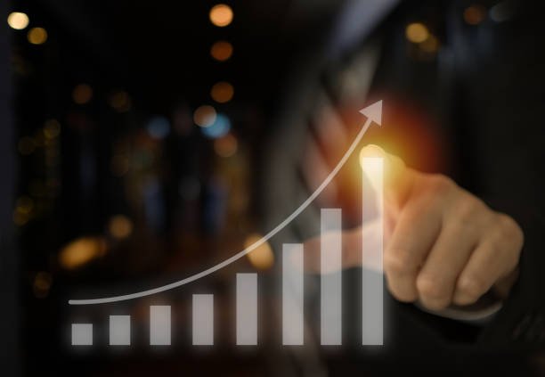 Businessman financial indicator and the stock market investment growth, with bar chart growing on a visual touch screen.